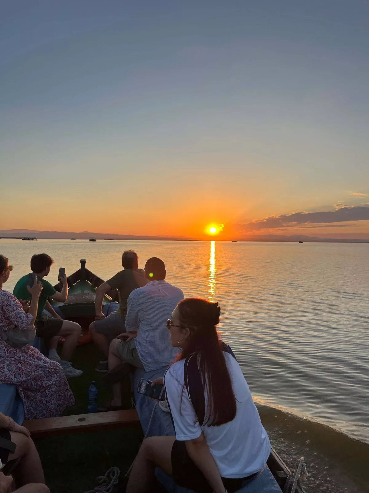 Paseo en barca al atardecer en la Albufera de Valencia con turistas disfrutando de la puesta de sol